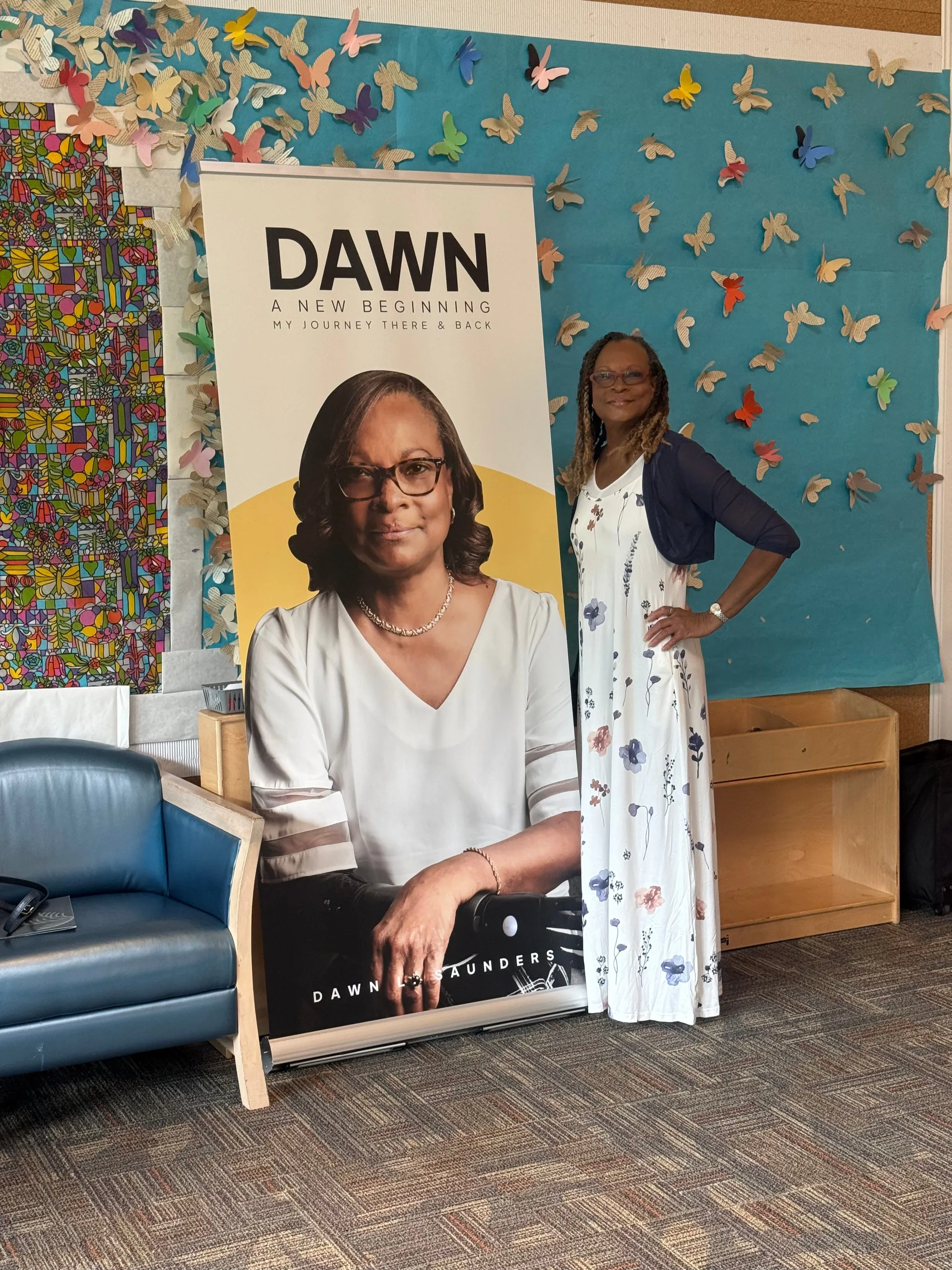 Dawn beside her book banner at an author event