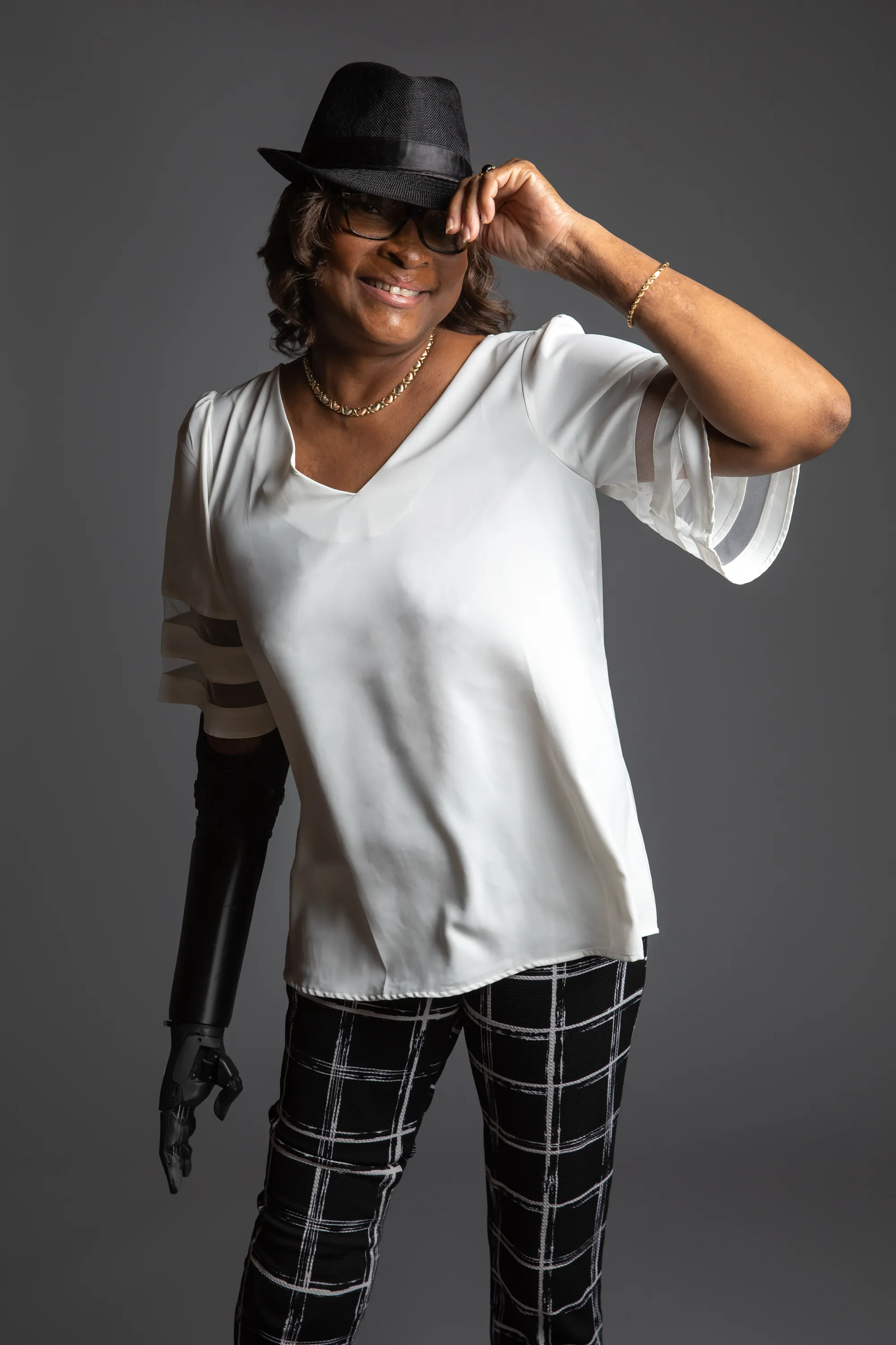 Author Dawn L. Saunders smiling and tipping a black fedora